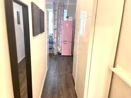 慕尼黑慕尼黑公寓式酒店的走廊上,房间里装有粉红色冰箱