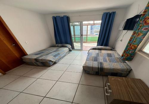 巴拉奈里奥-坎布里乌Residencial Louise的两张床位于带窗户的房间内