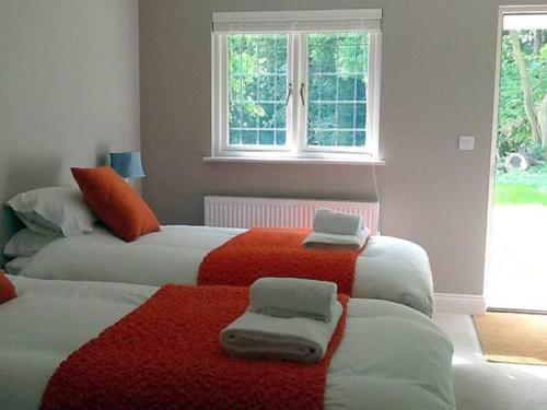 Holton花园小屋住宿加早餐旅馆的一间卧室配有两张带毛巾的床