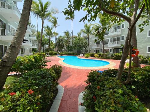 蓬塔卡纳Ducassi Sol Caribe Beach的棕榈树和建筑的度假游泳池