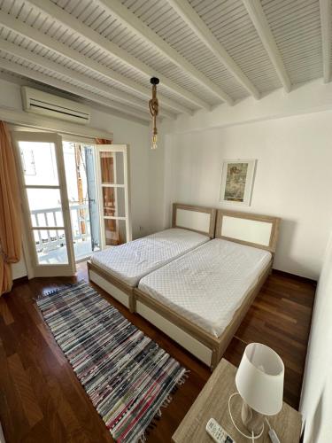 Megali AmmosMyconian Avra Apartment的一间卧室配有一张床、一张桌子和一个窗户。
