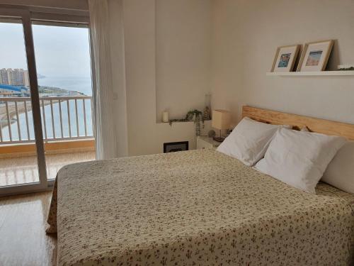 拉曼加戴尔马尔梅纳La Manga - Puerto y Playa - 3 dormitorios的一间卧室设有一张床,享有阳台的景色