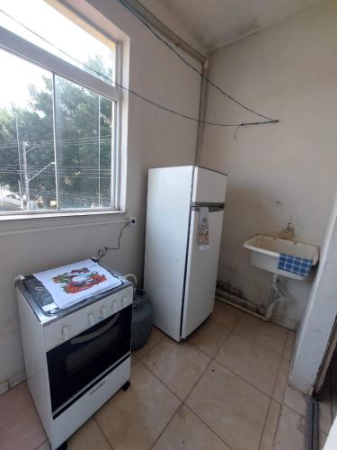 瓜拉廷格塔Apartamento aconchegante的厨房配有炉灶和冰箱。
