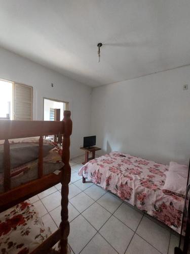 瓜拉廷格塔Apartamento aconchegante的一间卧室配有一张床和一台电视
