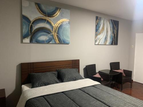 利马Iguana Haus Lima的卧室配有一张床,墙上挂有两幅画