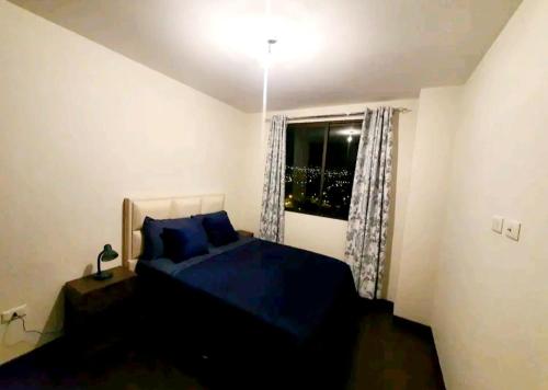 科恰班巴Acogedor departamento con 2 dormitorios的一间卧室设有蓝色的床和窗户。