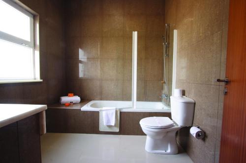 马普托马普托蒙特贝罗英迪会议酒店的带浴缸、卫生间和淋浴的浴室。