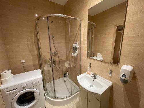 波兹南Lullaby Private Rooms的带淋浴、盥洗盆和洗衣机的浴室