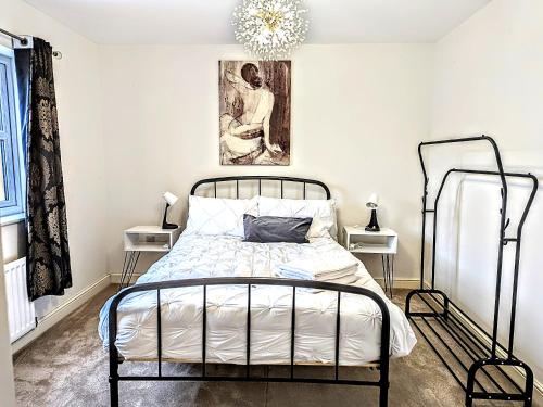 达灵顿Lovely 3 Bed Home for Colleagues的一间卧室配有锻铁床和吊灯。