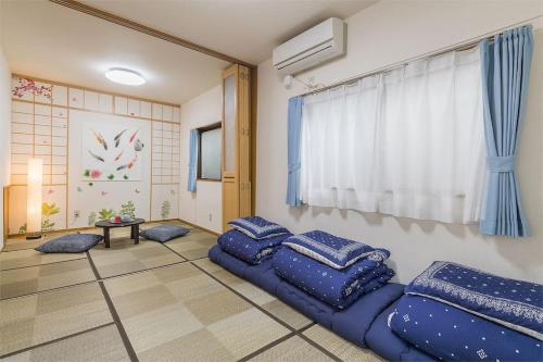东京Shinjuku12min Shibuya15min Max10ppi Free-Wifi的客厅配有蓝色枕头,位于地板上