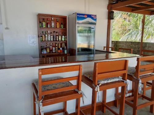 爱妮岛布卡纳海滨宾馆的酒吧配有四把椅子和冰箱