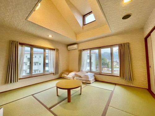 由布市湯布院 ソナタ Yufuin Sonata的客厅配有桌子和2扇窗户