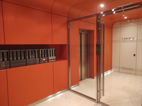 布尔戈斯Cordón 4的更衣室设有橙色墙壁和玻璃门