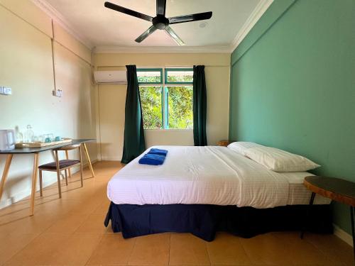 Kampung Tekekpapaya resort的一间卧室配有一张床、一张桌子和一个窗户。