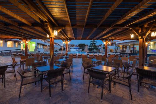 蒂加基盖亚村酒店的一间带桌椅和灯光的餐厅