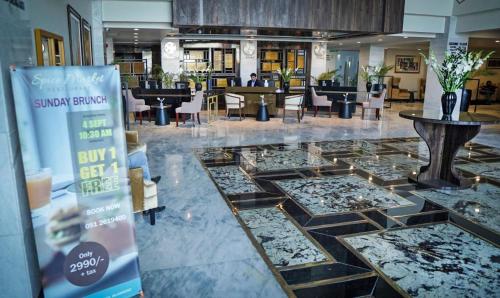 伊斯兰堡IFQ Hotel & Resort的大堂设有玻璃地板和桌椅
