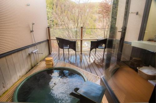 日田市真诚日式旅馆的甲板上的热水浴池配有桌椅
