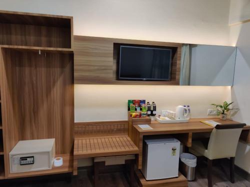 孟买巴瓦瑞跟酒店的客房设有书桌和墙上的电视