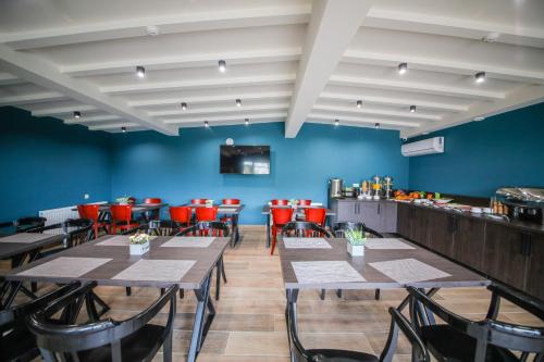 库塔伊西Hotel InnDigo in Kutaisi的一间配备有桌椅的用餐室和蓝色的墙壁