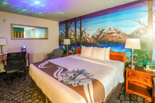 塞奎姆Quality Inn & Suites Sequim at Olympic National Park的酒店客房的墙上设有一张带绘画的床铺。