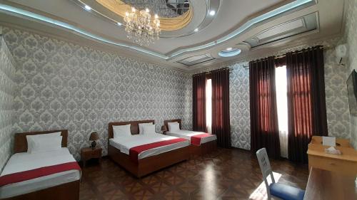 布哈拉Villa Oasis的酒店客房设有两张床和吊灯。