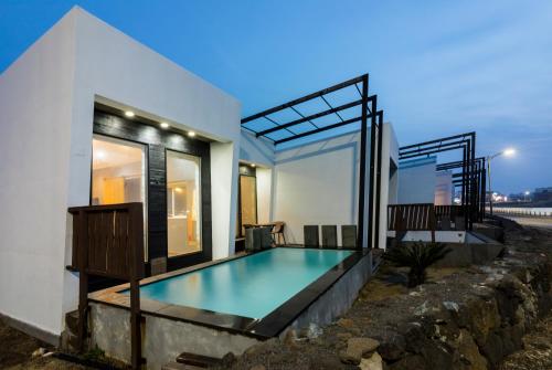 济州市Aqua Beautique Poolvilla的一座房子前面设有游泳池