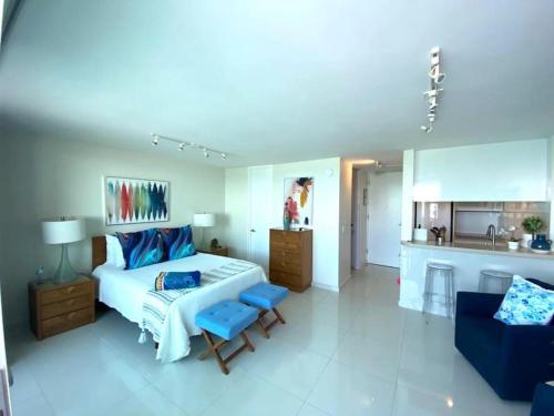 圣胡安KASA Terrace Studio Breathtaking Ocean Views的一间卧室配有一张床和一张沙发,还设有一间厨房