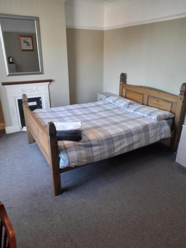 Immingham黑牛旅馆的一间卧室设有一张木床和壁炉