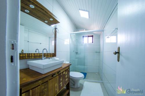 格拉瓦塔尔Pousada Gravatá的一间带水槽、卫生间和镜子的浴室