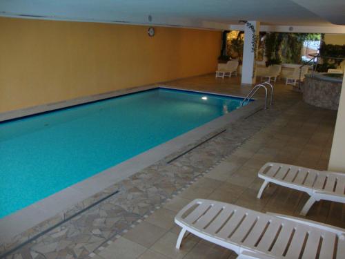 罗恩佐斯特拉阿尔皮康体和度假酒店的一个带2个躺椅的游泳池和一个游泳池