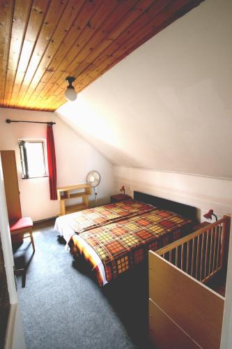 扎马迪Nefelejcs的一间卧室设有一张床和木制天花板