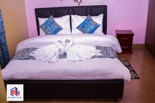 Homa BayBelmont Hotel Homabay的一间卧室配有一张带两翼白色床的卧室