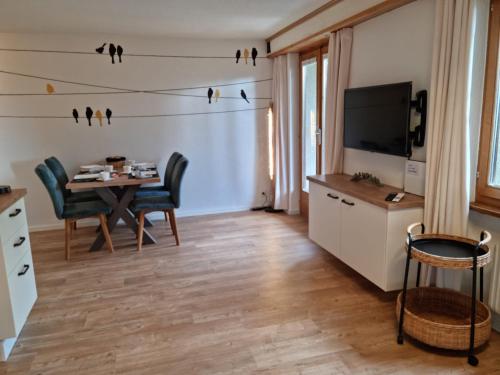 布里恩茨Gemütliche Ferienwohnung zwischen See und Bergen的客厅配有餐桌和电视