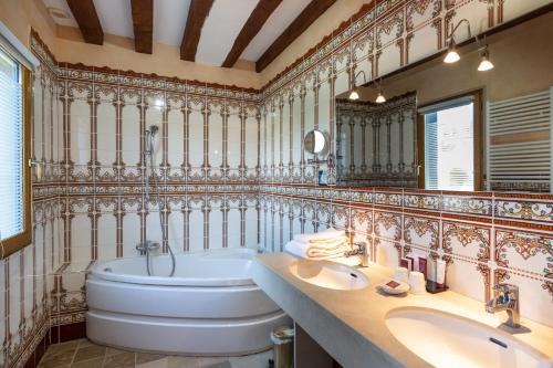 瑞米耶日克洛斯喷泉酒店的浴室配有两个盥洗盆和浴缸。
