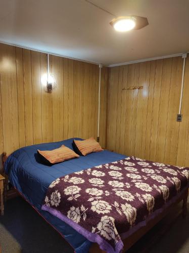 卡斯特鲁La Minga Hostel的木镶板客房内的一张床位