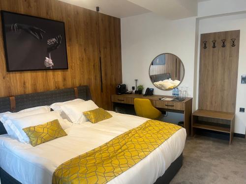 塞夫利耶沃Hotel NIKS的一间卧室配有一张床和一张带镜子的书桌