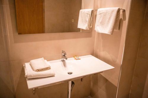 阿尤恩Sahara Line Hotel的浴室配有盥洗盆、镜子和毛巾