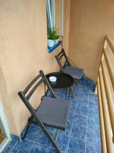 鲁马Apartman Stojadinović的阳台配有2把椅子和1张桌子