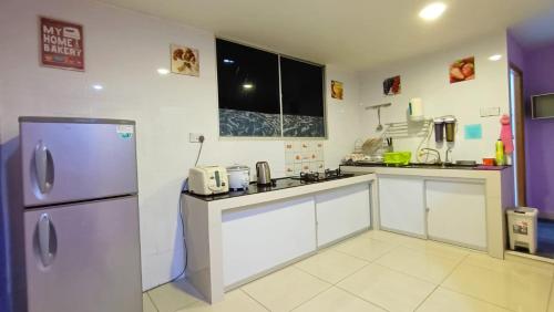米里Taman Tunku Miri Budget Homestay的厨房配有不锈钢冰箱和白色橱柜