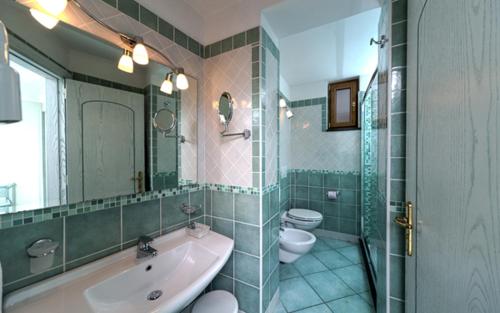 伊斯基亚贝尔维尤健身及放松酒店的一间带水槽、卫生间和镜子的浴室
