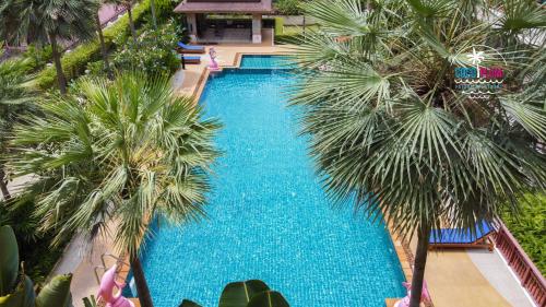 芭东海滩Patong Coco Apartment的享有棕榈树游泳池的顶部景致