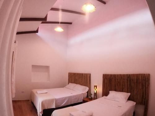 莫约班巴Muyuterra的白色墙壁客房的两张床