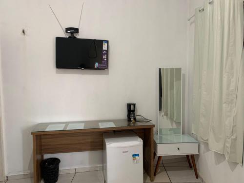 巴雷里尼亚斯Pousada Meu Xodó的一间设有一张桌子的房间,墙上配有电视