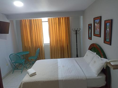 齐克拉约HOTEL ALFONSO UGARTE的一间卧室配有一张床、两把椅子和一个窗户