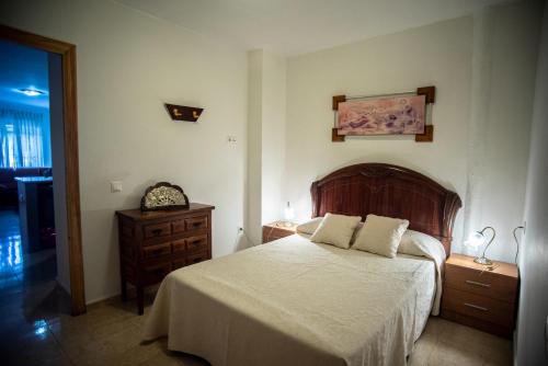 比利亚罗夫莱多APARTAMENTOS SAN ANTON的一间卧室配有一张床和一个带两盏灯的梳妆台。