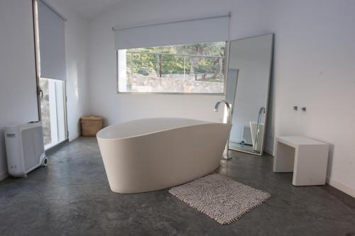卡迪瓦拉马加客房的带窗户的浴室内的白色浴缸