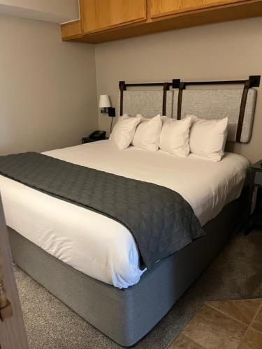 布雷肯里奇Slope Side Ski In Ski Out at Beaver Run Resort的卧室配有一张带白色床单和枕头的大床。
