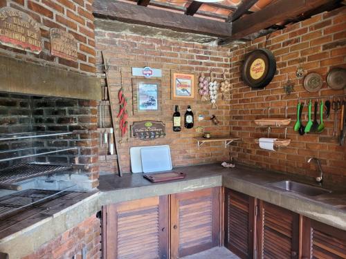 特雷索波利斯Chalé Casa de Esther的厨房设有水槽和砖墙