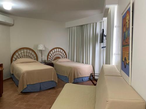 圣多明各太阳广场公寓式酒店的酒店客房,设有两张床和一张沙发