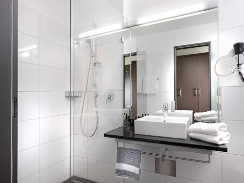 莱茵费尔登Boutique Hotel Bellevue Rheinfelden / Basel的白色的浴室设有水槽和淋浴。